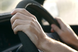 someone driving a car and holding the steering wheel