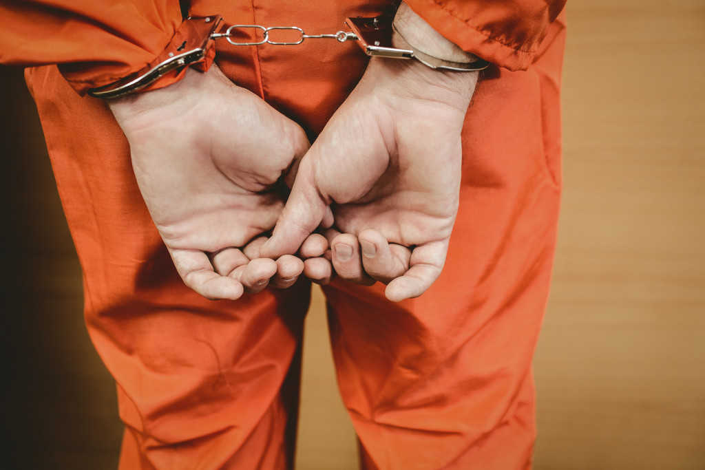 man in handcuffs in orange jumpsuit man in handcuffs in orange jumpsuit