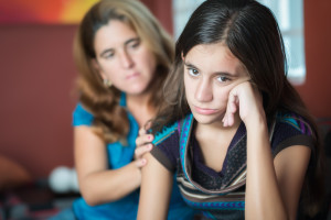 young teen upset and being comforted by mother