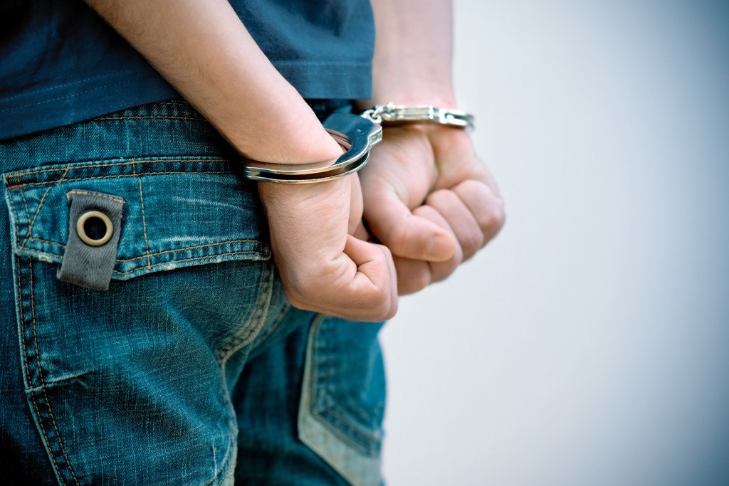 man in handcuffs in orange jumpsuit